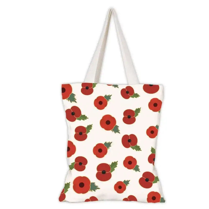 A canvas tote bag with a repeating pattern of red poppies with green leaves on an off-white background, featuring two cream-colored shoulder straps.