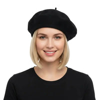 A smiling blonde woman wearing a navy blue beret and a black top, photographed against a clean white studio background.