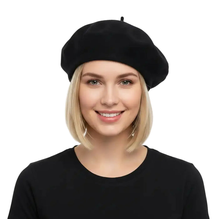 A smiling blonde woman wearing a navy blue beret and a black top, photographed against a clean white studio background.