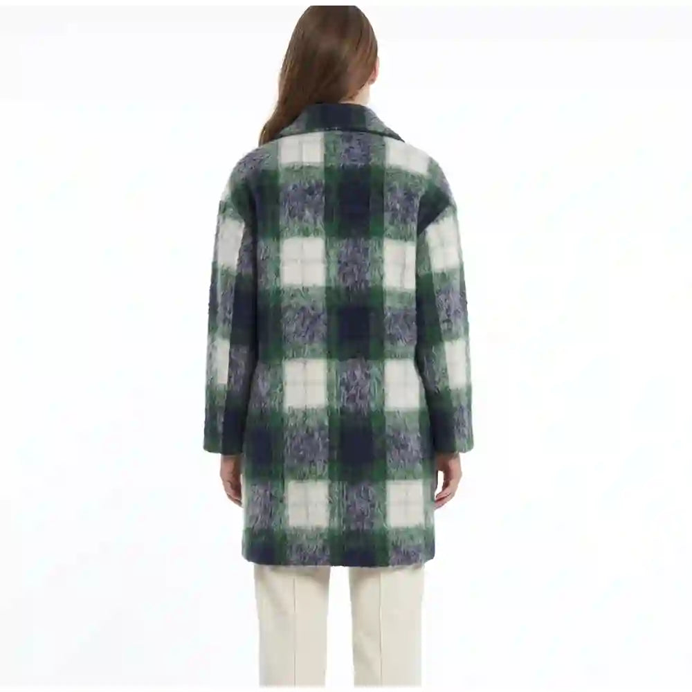 A woman viewed from the back wearing a green, navy, and off-white plaid coat over cream pants, set against a plain white background.