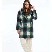 A woman modeling a mid-length green and white plaid coat with a fuzzy texture, paired with cream-colored pants, against a plain white background.