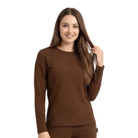 A woman with long brown hair wearing a solid brown long-sleeve crewneck top and matching brown bottoms, standing against a clean white studio background.