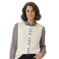 A woman wearing a cream ribbed knit vest over a gray collared shirt, featuring colorful buttons down the front.