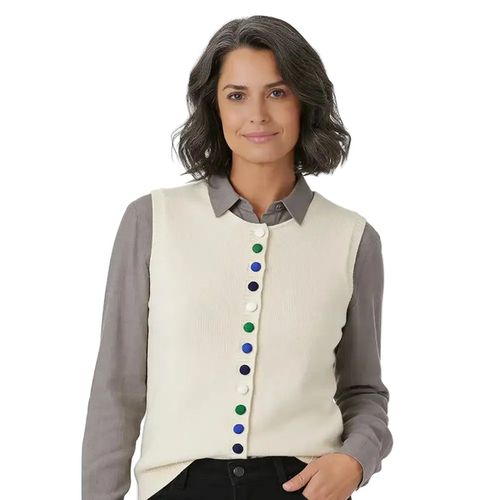 A woman wearing a cream ribbed knit vest over a gray collared shirt, featuring colorful buttons down the front.