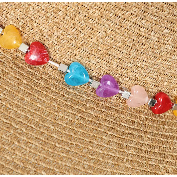 Natural straw coloured hat with heart shaped eads round crown.