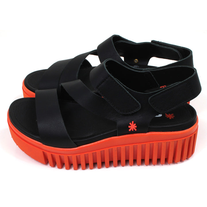 Art black sandals. Black footbed and bright orange ridged orange soles. Side view.