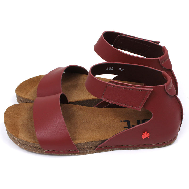 Art red tan sandals with single wide footstrap and Velcro fitting around the ankle. Tan coloured footbeds. Side view