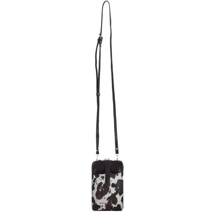 A small crossbody phone bag with a black and white cow print body and a solid black strap, shown against a plain white background.