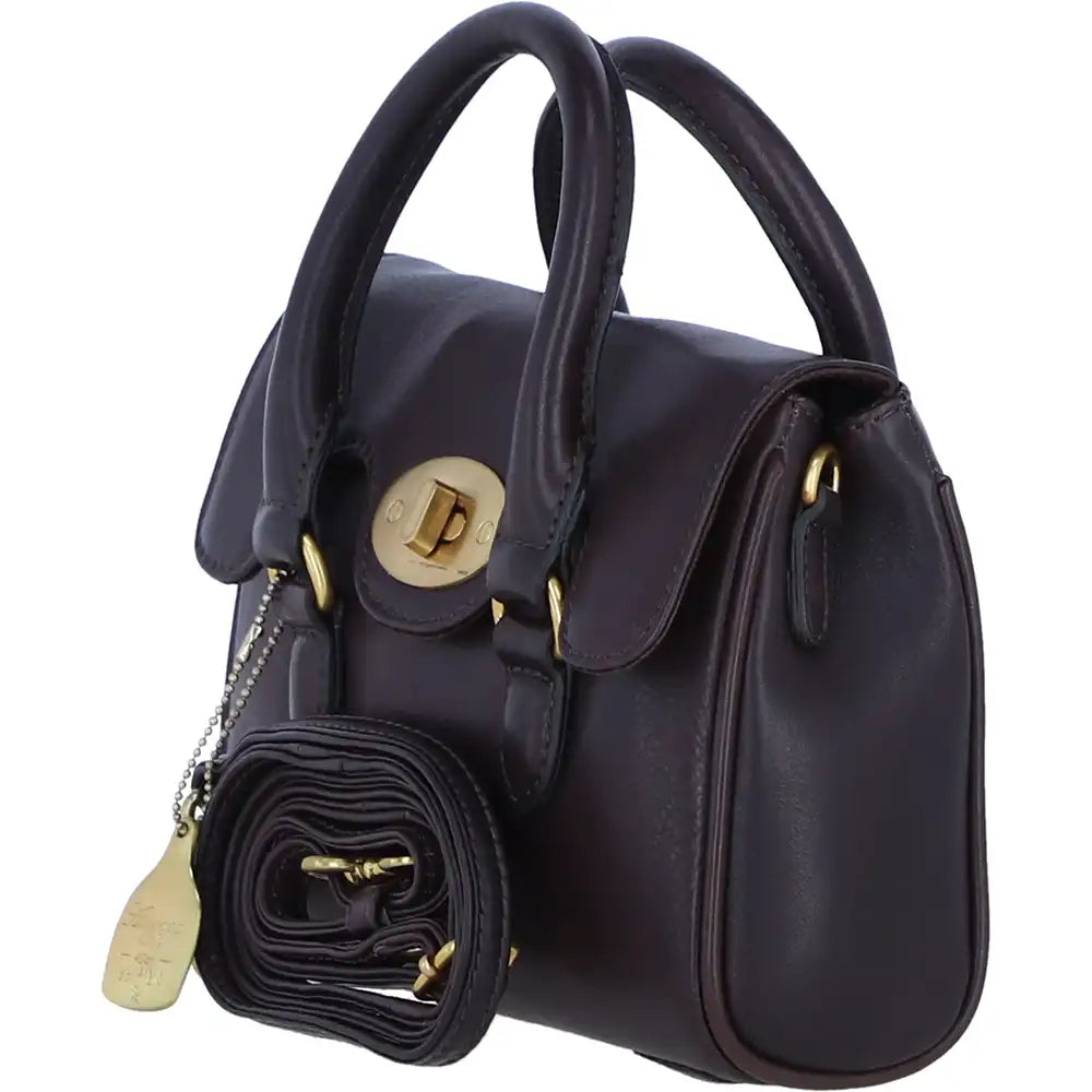 A dark navy blue leather handbag with gold-tone hardware, featuring dual top handles, a front flap with a turn-lock closure, and a matching rolled black pouch with a gold tag hanging from the side.