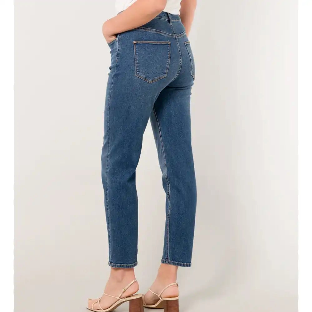 Person wearing blue jeans on a plain background