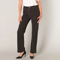 A model wearing a pair of dark charcoal gray wide-leg jeans, styled with a white top and black patent high heels, standing against a light gray studio background.