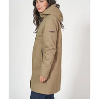 Woman wearing a beige parka with a visible brand logo on a white background