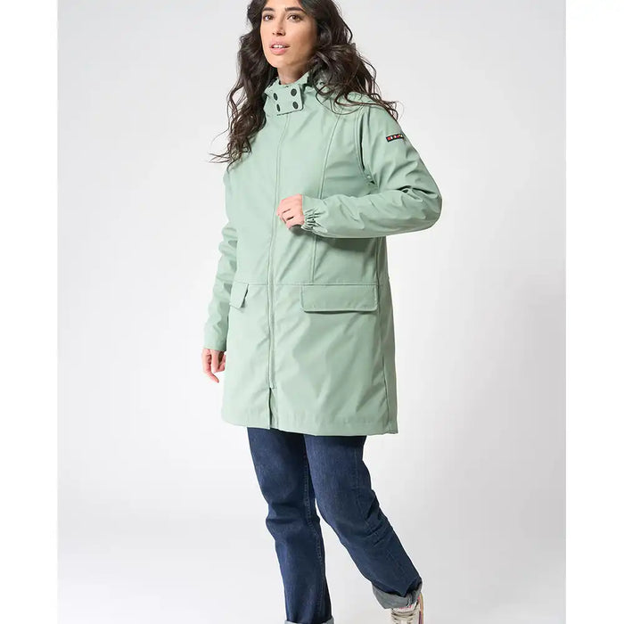 Woman wearing a light green coat on a white background