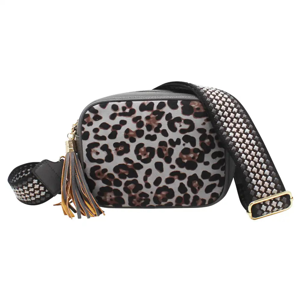A leopard print crossbody bag with a wide, patterned woven strap, gold-tone hardware, and a decorative tassel, shown against a plain white background.