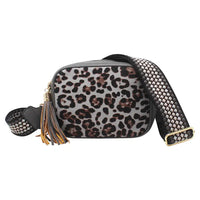 A leopard print crossbody bag with a wide, patterned woven strap, gold-tone hardware, and a decorative tassel, shown against a plain white background.