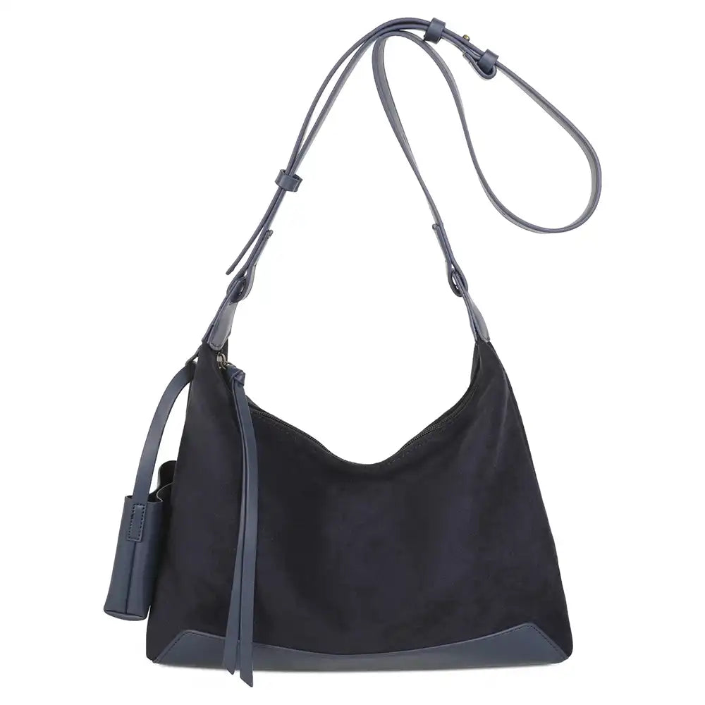 A black suede hobo shoulder bag with dark gray leather trim, a matching shoulder strap, and a small hanging leather tag, shown against a plain white background.