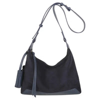 A black suede hobo shoulder bag with dark gray leather trim, a matching shoulder strap, and a small hanging leather tag, shown against a plain white background.