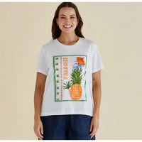 Model wearing a white tee shirt with a green boarded square that has a pineapple, fish and the word Paradise in it. Round neckline and short sleeves. 