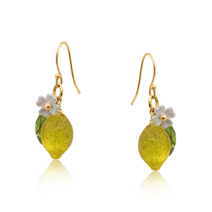 Yellow resin earrings with a white flower and green leaf attached to a golden coloured hook. 