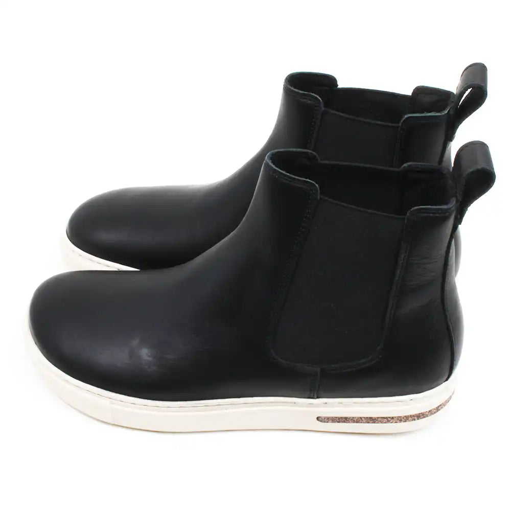 Birkenstock Bend Chelsea boots in black with cream coloured soles. Elasticated ankle side panels. Pull tabs at the back. Side view.