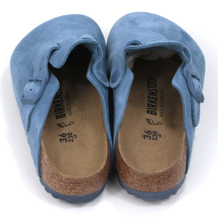Birkenstock sky blue suede clogs with buckled strap. Open backs and sculpted inner soles. Cork and rubber soles. Back view.