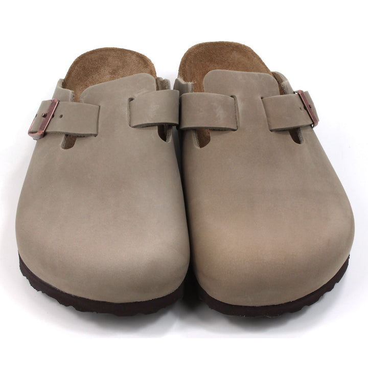 Birkenstock enclosed feet, open back clogs. Brown sculpted inner sole. Black rubber soles. Mid brown with copper coloured buckle on cross foot adjustment strap. Front view.