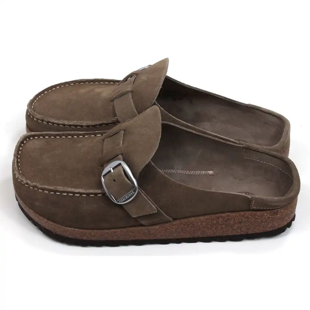 Birkenstock Buckley mid taupe mule shoes with over the foot strap with silver buckle. Moccasin styling. Cork and black rubber soles. Side view.