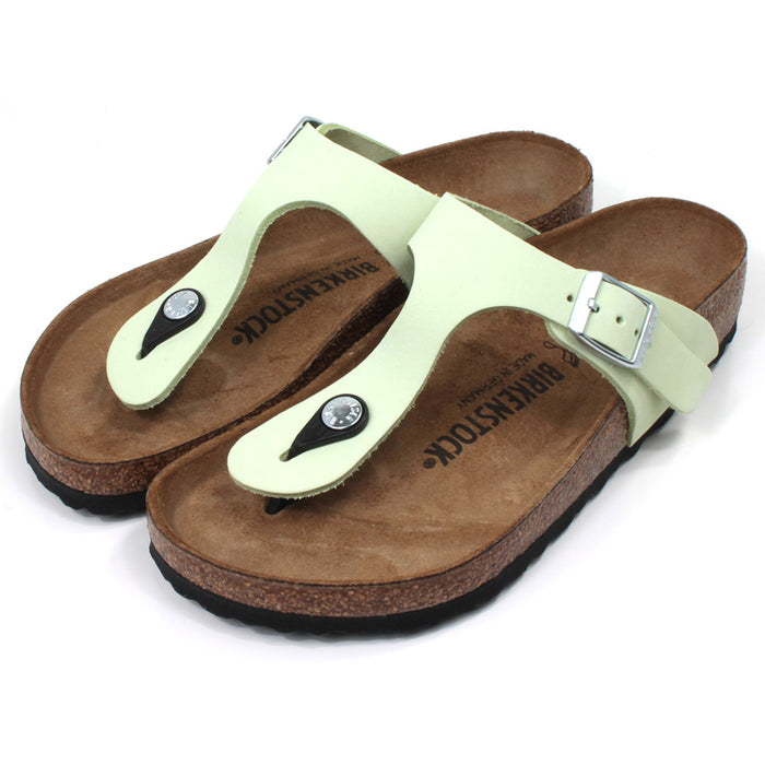 Birkenstock Gizeh toe post sandals in faded lime colour. Cork sculpted insoles and black rubber soles. Silver side buckle. Angled view.