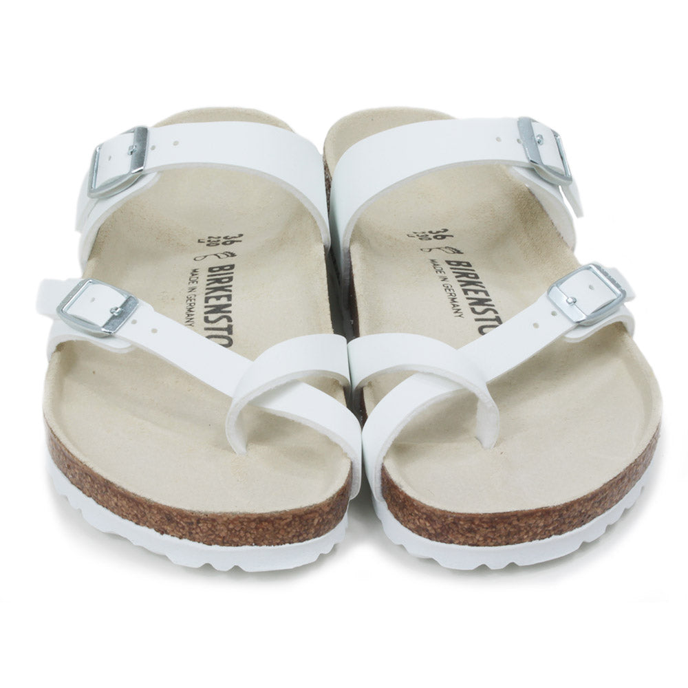Birkenstock Mayari three strap white sandals. Silver buckles for adjustment. Strap to fit between toes. Open backs. Cork insoles with white soles. Front view.