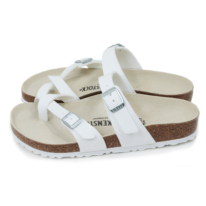 Birkenstock Mayari three strap white sandals. Silver buckles for adjustment. Strap to fit between toes. Open backs. Cork insoles with white soles. Side view.
