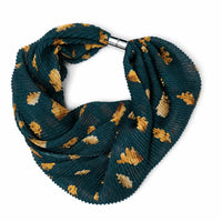 A pleated infinity scarf in dark teal green with a pattern of mustard yellow and cream leaves, secured with a silver metal clasp, shown on a plain white background.