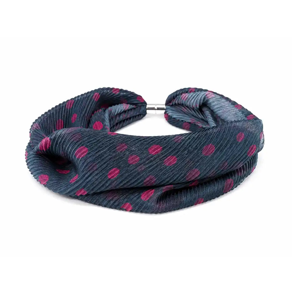 A dark gray ribbed fabric headband with a pink polka dot pattern and a silver metal clasp, shown on a plain white background.