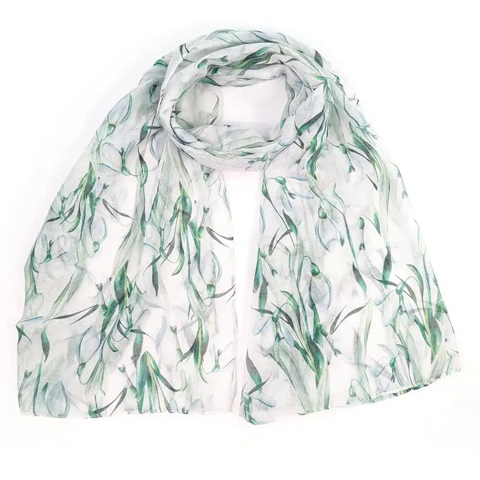 A lightweight white scarf with a watercolor-style green botanical print, draped and folded on a plain white background.