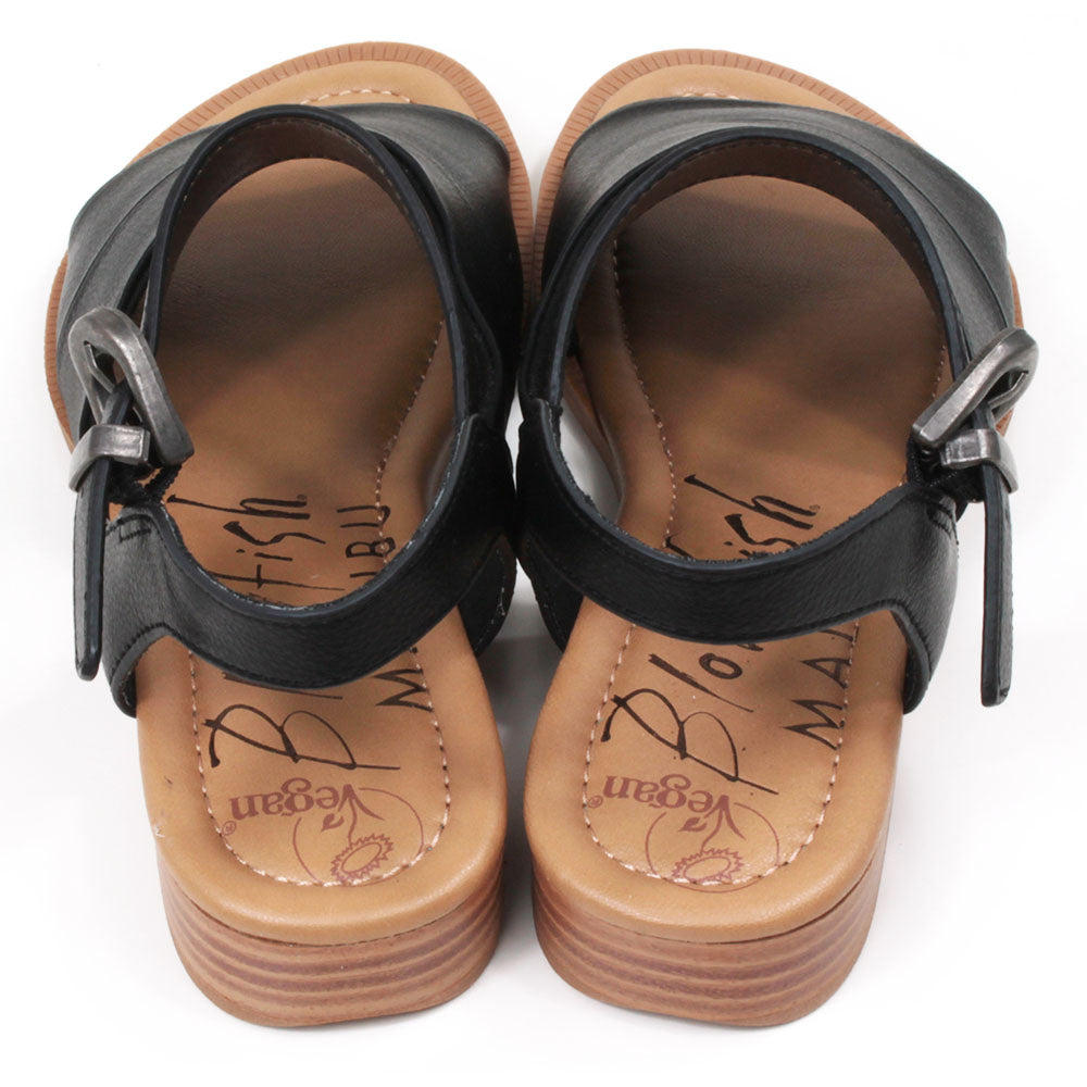 Blowfish Malibu black sandals with buckled over the ankle straps. Light brown soles. Back view.