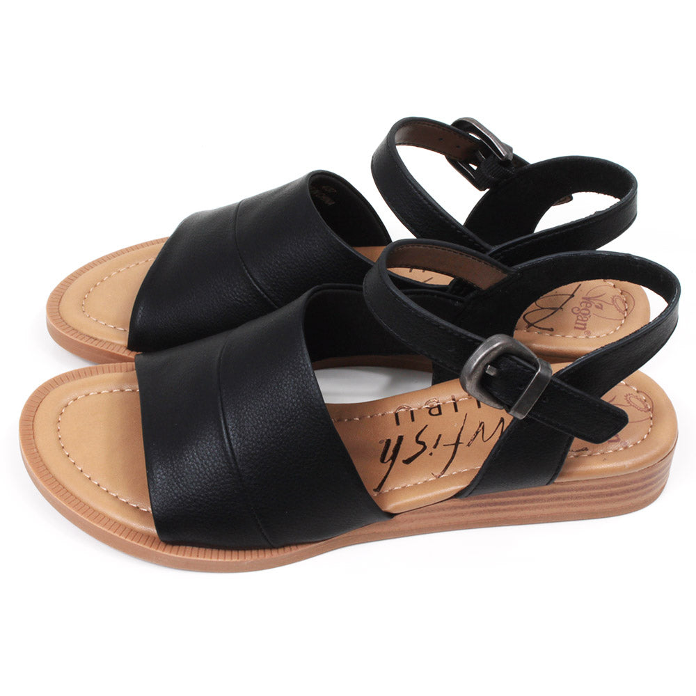 Blowfish Malibu black sandals with buckled over the ankle straps. Light brown soles. Side view.