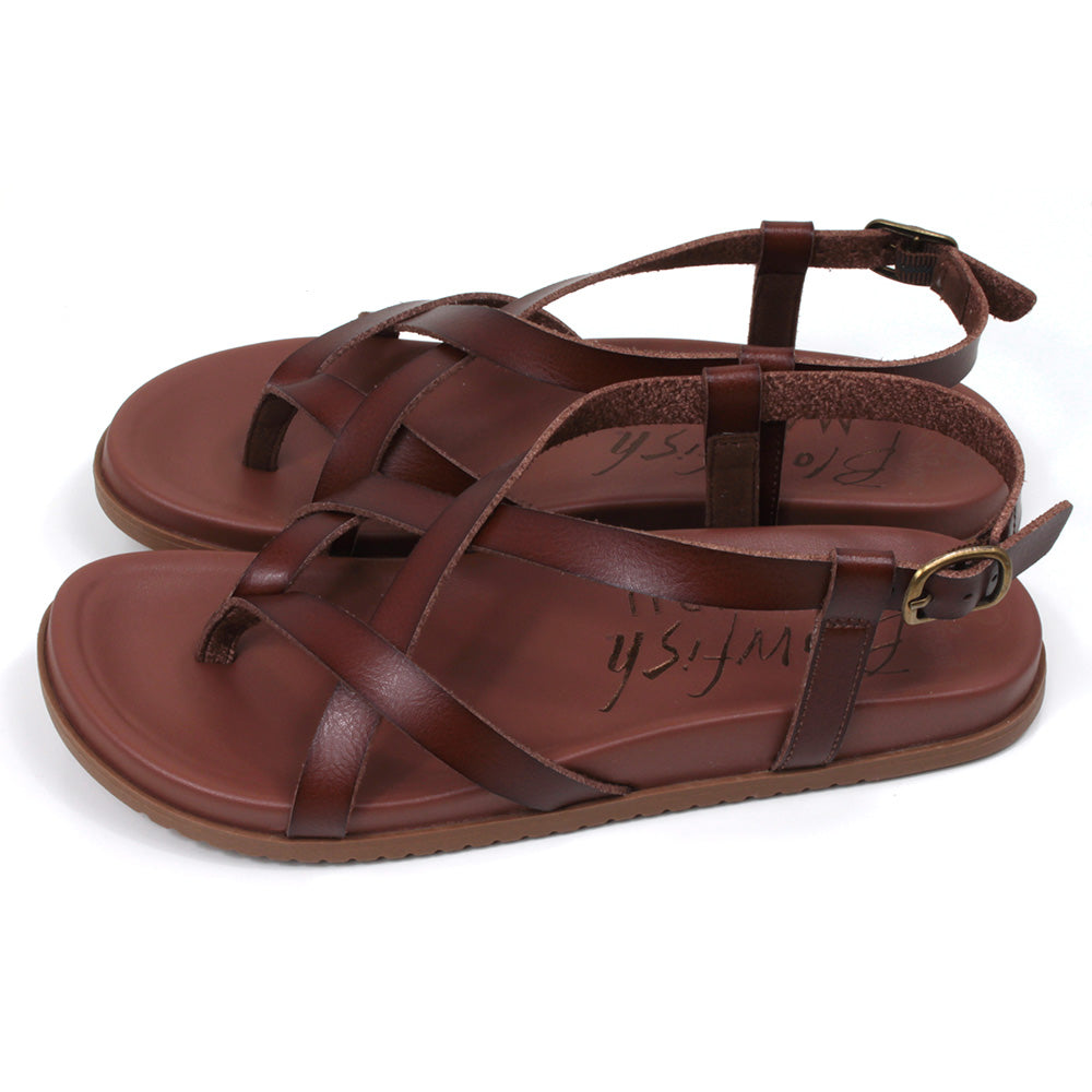 Blowfish Malibu strappy sandals in brown. Toe post style. Metal buckles for adjusting ankle straps. Side view.