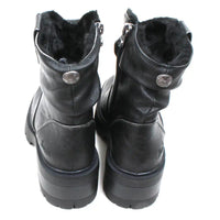 Blowfish Malibu Juniper Cozy boots in black. Very sturdy deep tread soles. Ruched design over the ankles and a clip detail. Furry interiors. Fitted with a zip. Back view.