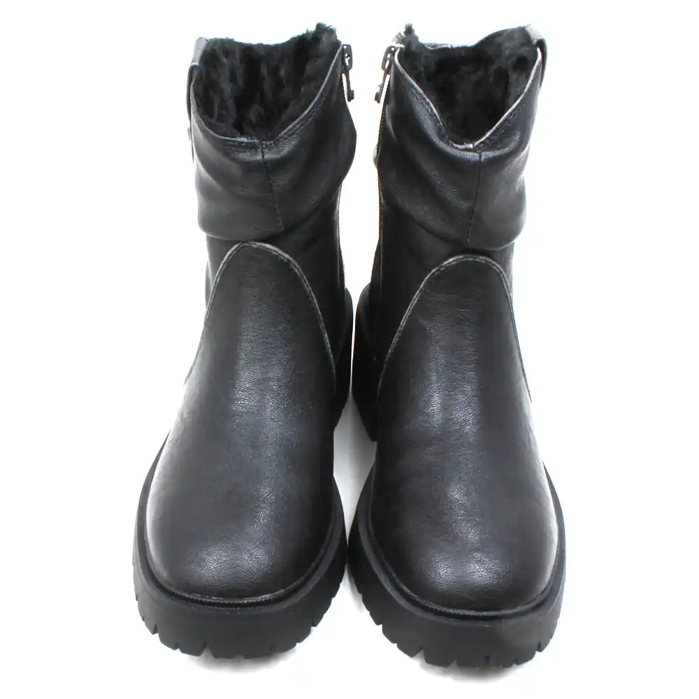 Blowfish Malibu Juniper Cozy boots in black. Very sturdy deep tread soles. Ruched design over the ankles and a clip detail. Furry interiors. Fitted with a zip. Front view.