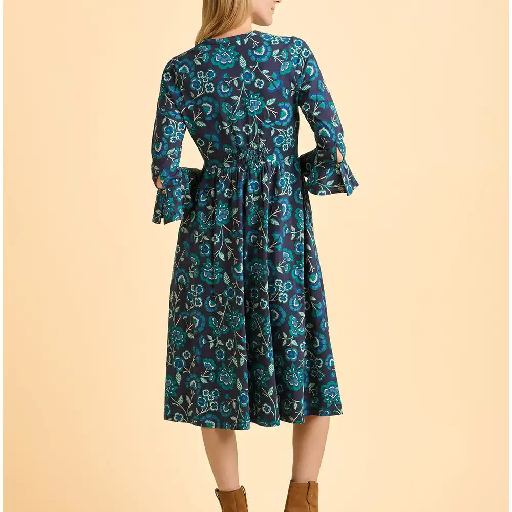 Woman wearing a blue floral dress on a beige background