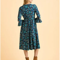 Woman wearing a blue floral dress on a beige background