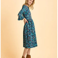 Woman wearing a blue floral dress on a beige background