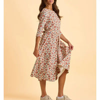 Woman wearing a floral dress on a beige background