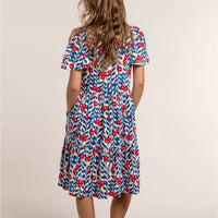 Woman wearing a floral dress with red flowers on a beige background