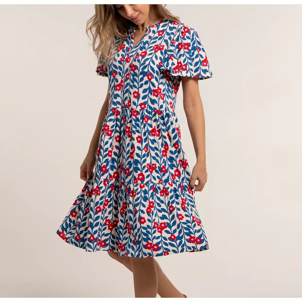 Woman wearing a floral dress with red flowers on a beige background