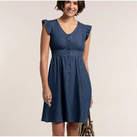 Woman wearing a blue denim dress against a plain background
