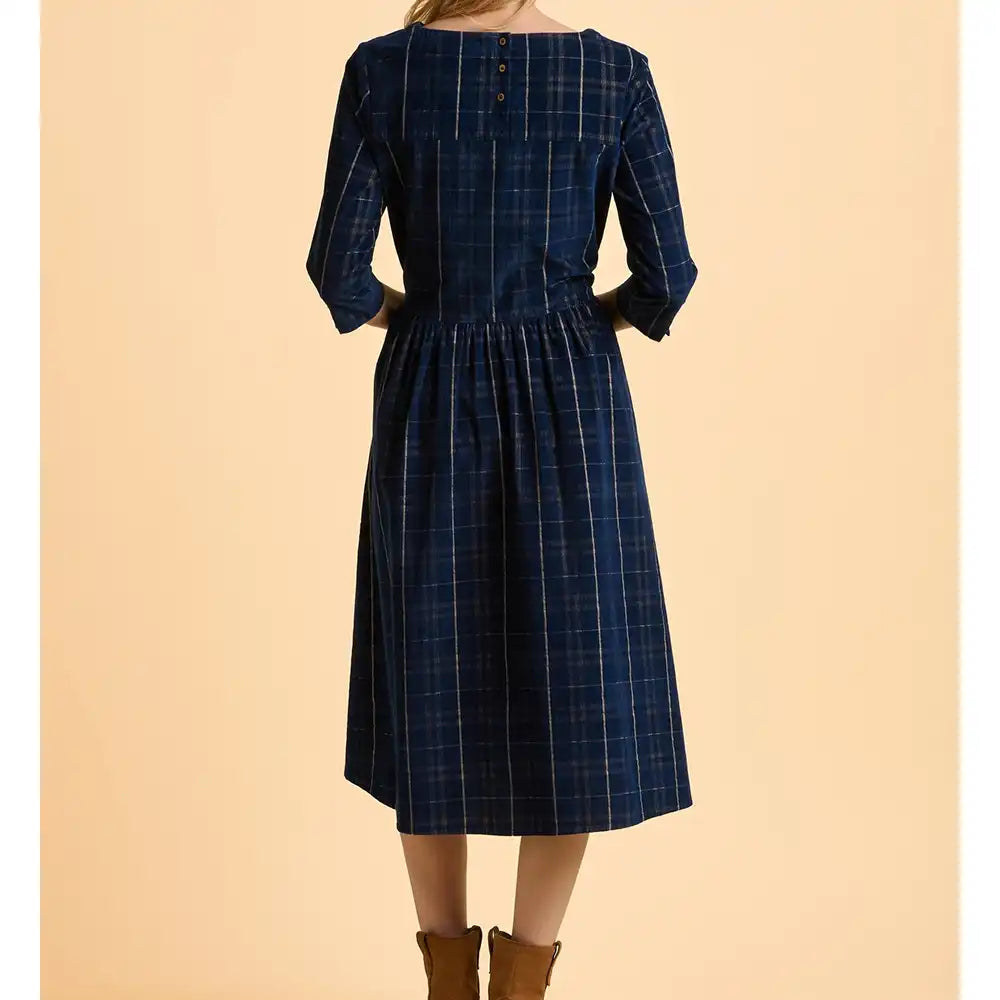 Blue plaid dress worn by a person on a beige background