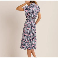 Woman wearing a floral dress with pink flowers on a beige background