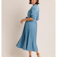 Woman wearing a blue dress against a beige background