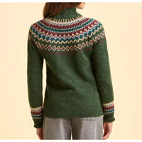 Green sweater with a colorful pattern on the back, worn by a person against a beige background