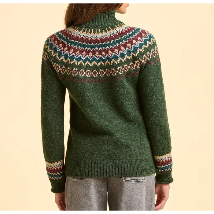 Green sweater with a colorful pattern on the back, worn by a person against a beige background